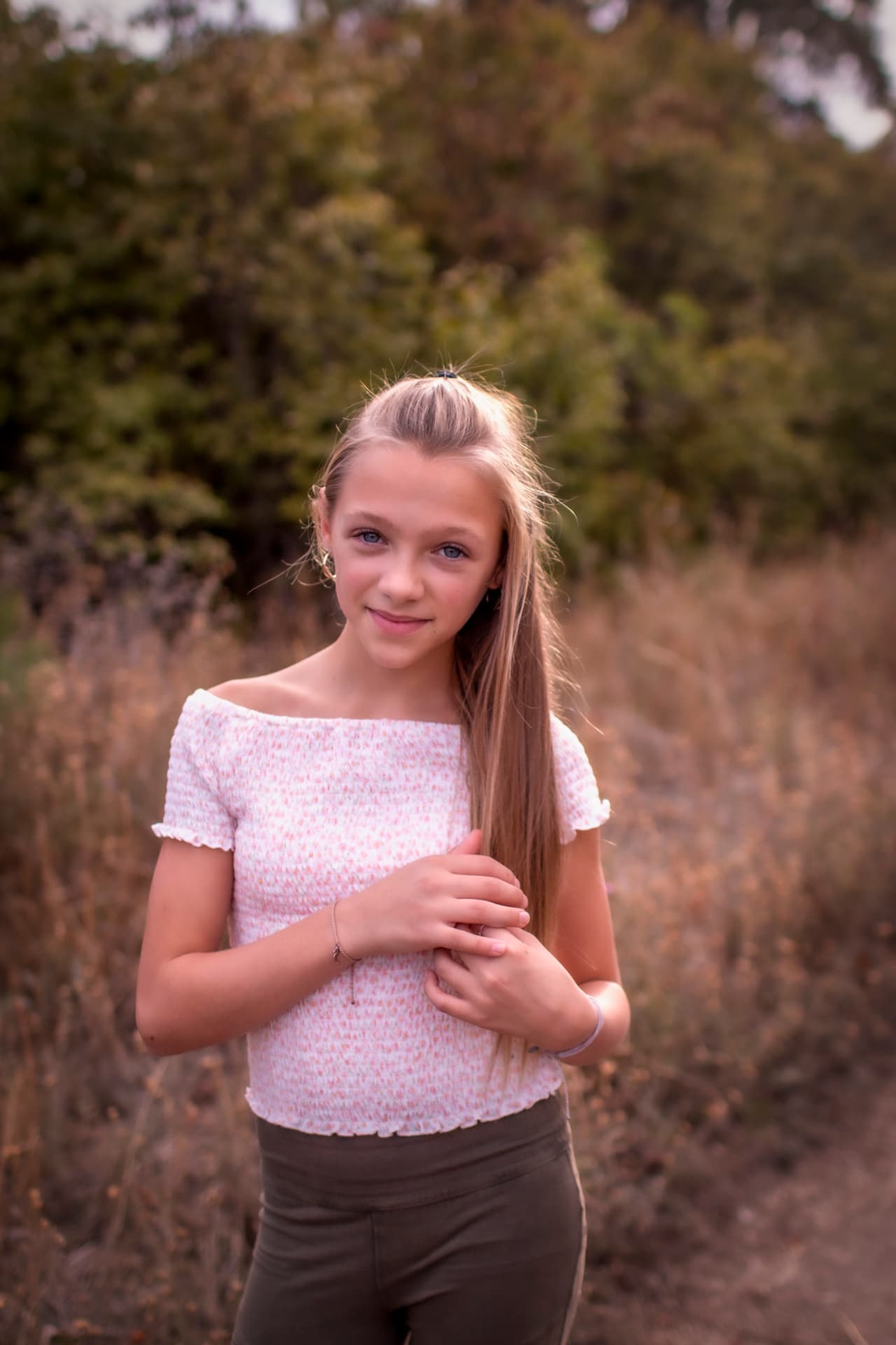 Girl standing in tall dry grass